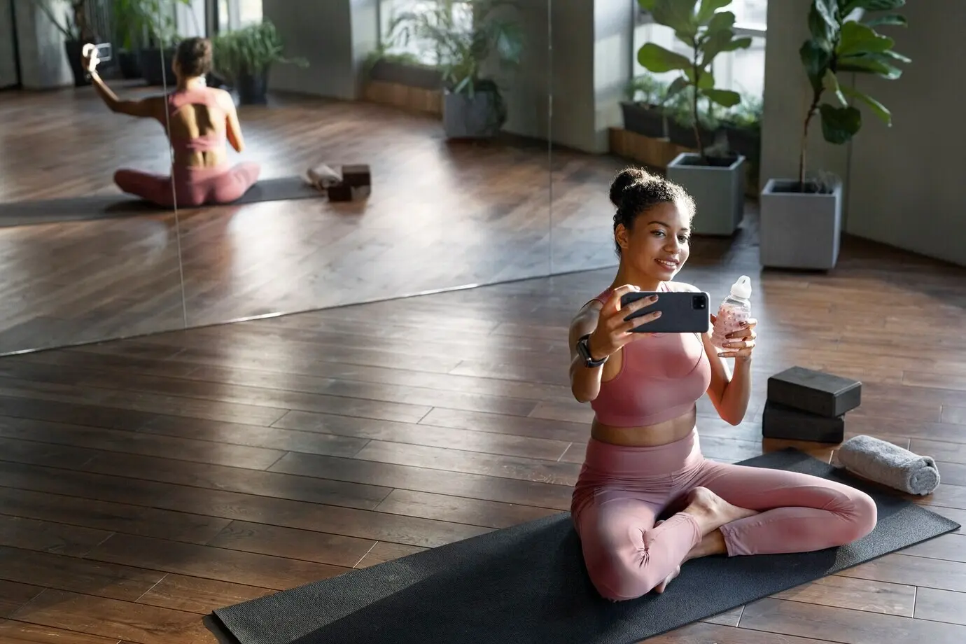 Ganzkörperaufnahme einer lächelnden Frau, die ein Selfie macht.